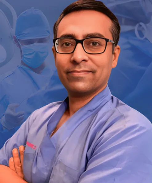 Portrait of a male surgeon in blue scrubs and glasses with arms crossed, in an operating room background.